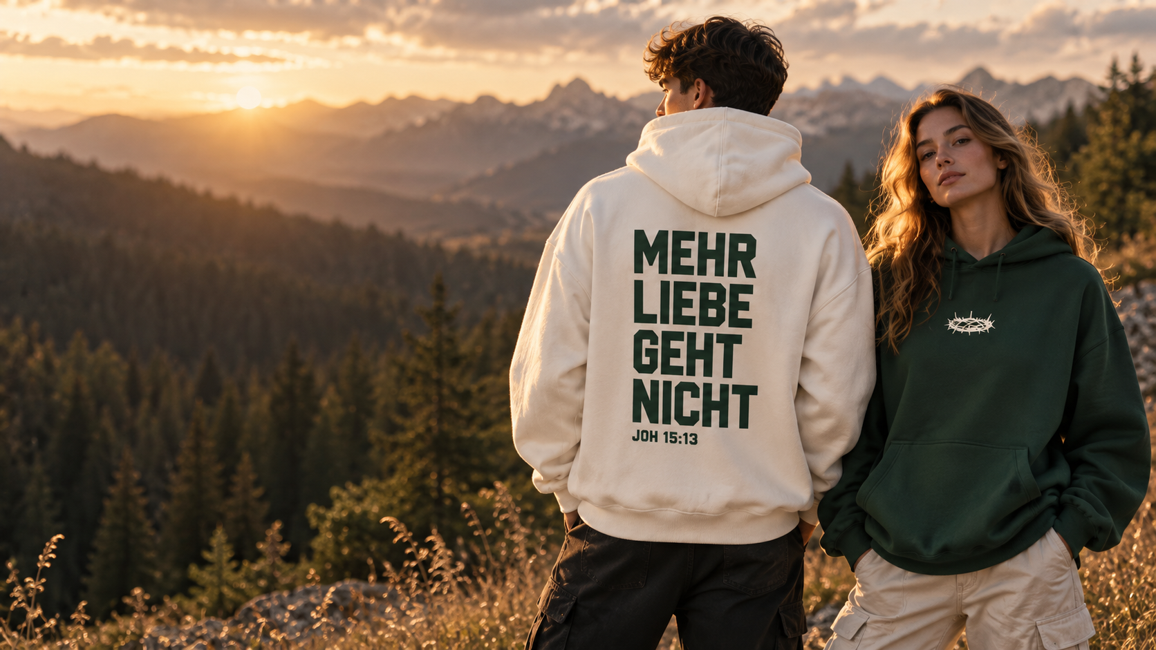 Zwei junge Erwachsene in der Natur mit einem cremefarbenen Mehr-Liebe-Hoodie von hinten und einem dunkelgrünen Hoodie mit Dornenkrone von vorne