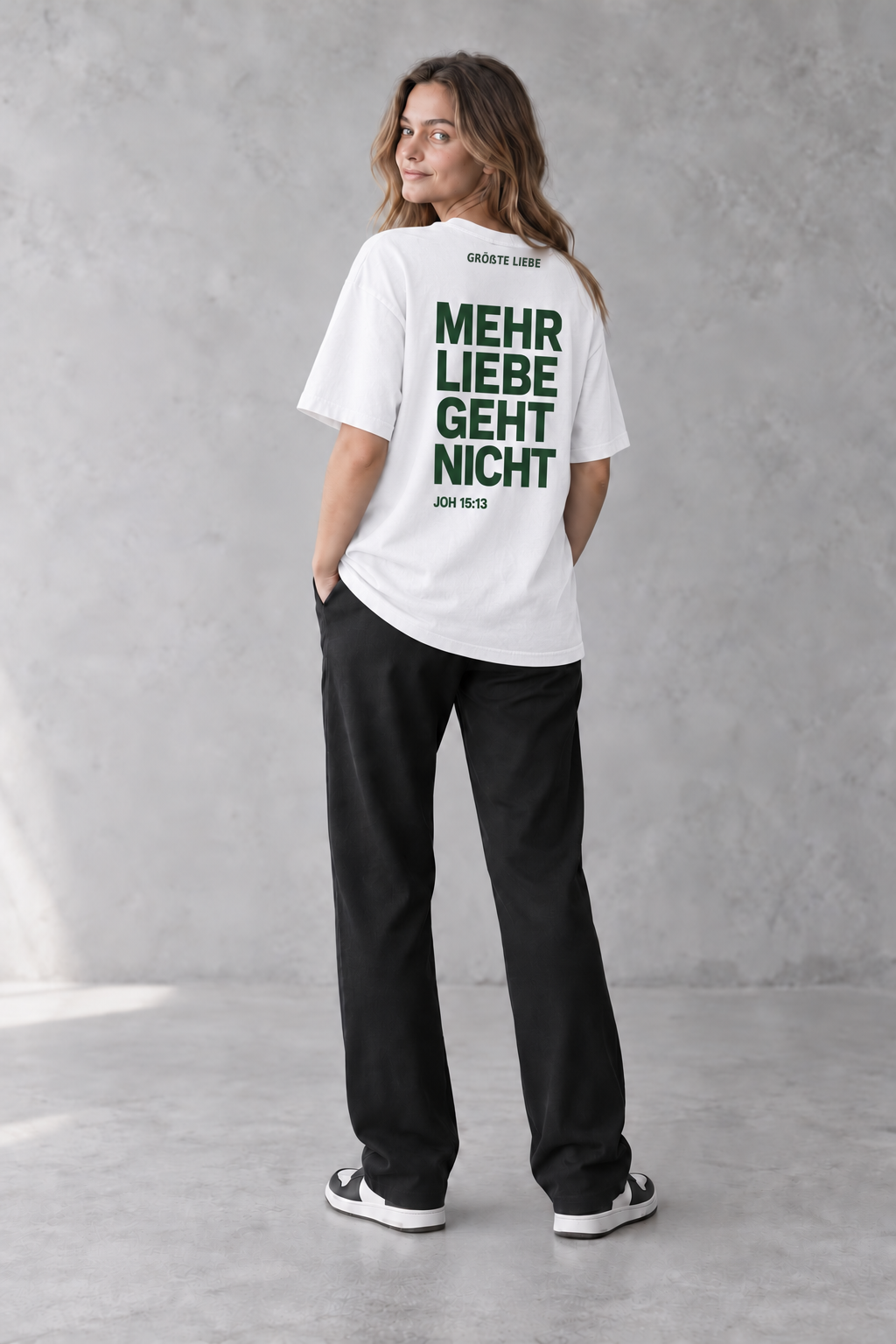 Weibliches Model mit weißem GRÖSSTE LIEBE Signature-T-Shirt und Johannes 15:13 von hinten